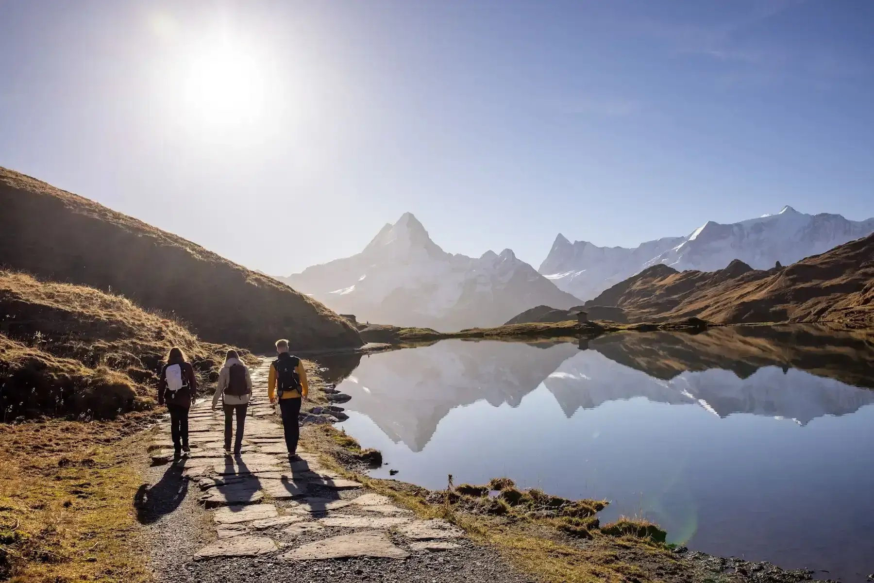 Hikers on the path beside Bachalpsee lake above Grindelwald